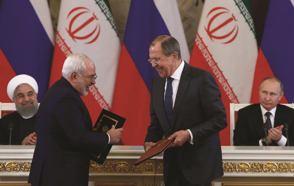 Russian Foreign Minister Lavrov (R) and Iranian Foreign Minister Zarif (L) exchange documents during a signing ceremony following a meeting of Russian and Iranian presidents at the Kremlin on March 28, 2017.  AFP PHOTO /  SERGEI KARPUKHIN
