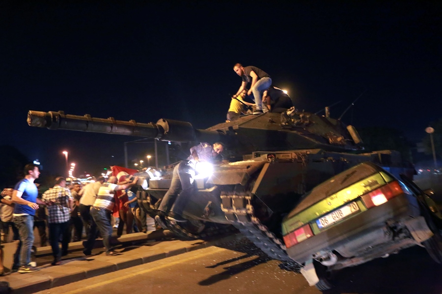 A tank crushes a car as people take to the streets in Ankara during the coup attempt.  AFP PHOTO /  ADEM ALTAN