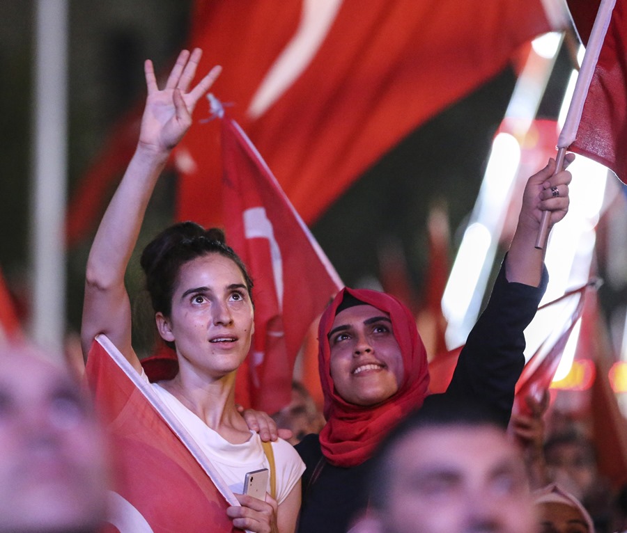 Two women, with differing lifestyles choices but united in their defense of democracy, wave Turkish flags to celebrate the victory of the people against the coup plotters, in the Southern city of Adana.   AA PHOTO /  SERHAT ÇAĞDAŞ