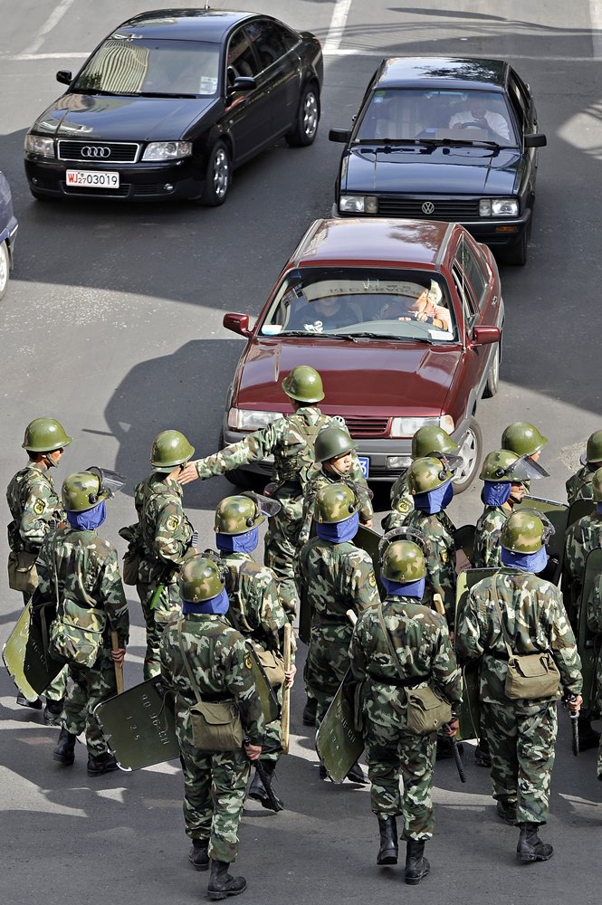 Chinese troops divert traffic in a street of Urumqi, the capital of the Xinjiang Uyghur autonomous region, on September 5, 2009. Some Han Chinese residents have blamed the Uighurs for the hundreds of reported syringe attacks in the city, but official reports have been vague about the identities of the alleged perpetrators, 21 of whom have been detained. AFP PHOTO / PHILIPPE LOPEZ