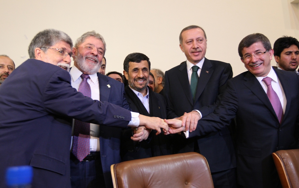 The representatives of Turkey, Brazil and Iran hold hands after Iran agreed to a nuclear fuel swap deal in Tehran on May 17, 2010. AFP PHOTO /  ATTA KENARE