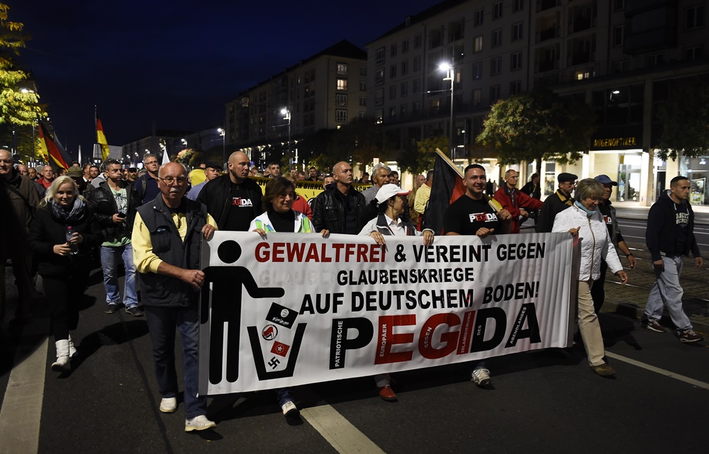 Supporters of the PEGIDA movement attend a protest rally on October 5, 2015 in Dresden. The banners read ‘Freedom for Germany. AFP PHOTO /  TOBIAS SCHWARZ