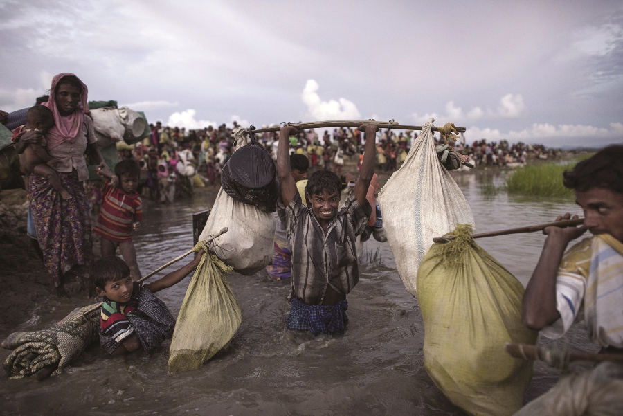 Forced to leave their homes, Rohingya refugees wade after crossing the Naf River from Burma into Bangladesh in Whaikhyang on October 9, 2017.  AFP PHOTO /  FRED DUFOUR
