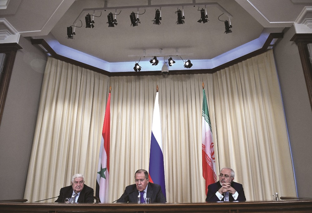 Russian Foreign Minister Lavrov (C) and his Iranian and Syrian counterparts, Zarif (R) and Muallem (L), hold a joint press conference in Moscow on April 14, 2017 after their talks about the U.S. strike on Assad’s forces following a suspected chemical weapons attack.  AFP PHOTO /  ALEXANDER NEMENOV