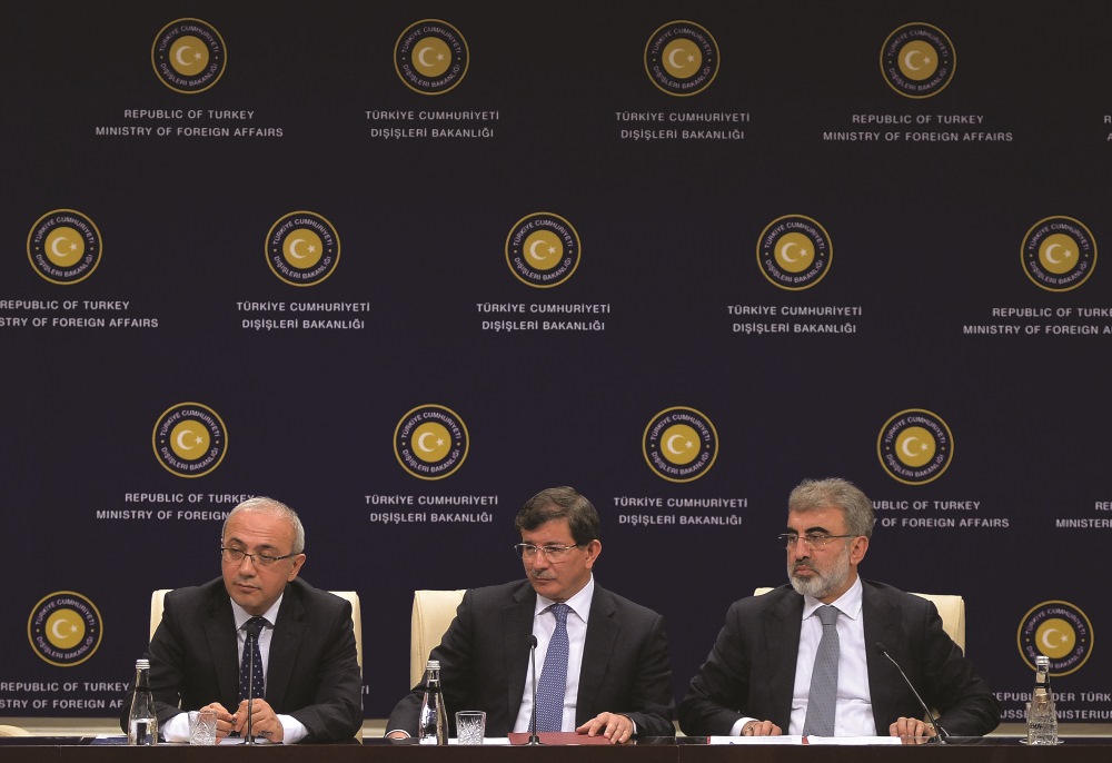 Then Turkish Foreign Minister Ahmet Davutoğlu speaks next to Turkish Energy Minister Taner Yıldız and Transport Minister Lutfi Elvan during a press conference in Ankara, on June 13, 2014.  AFP PHOTO /  ADEM ALTAN